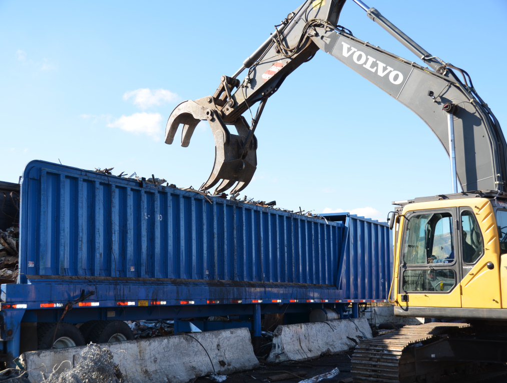 Photo of mechanical claw removing scrap metal from truck trailer, linking to photo album.