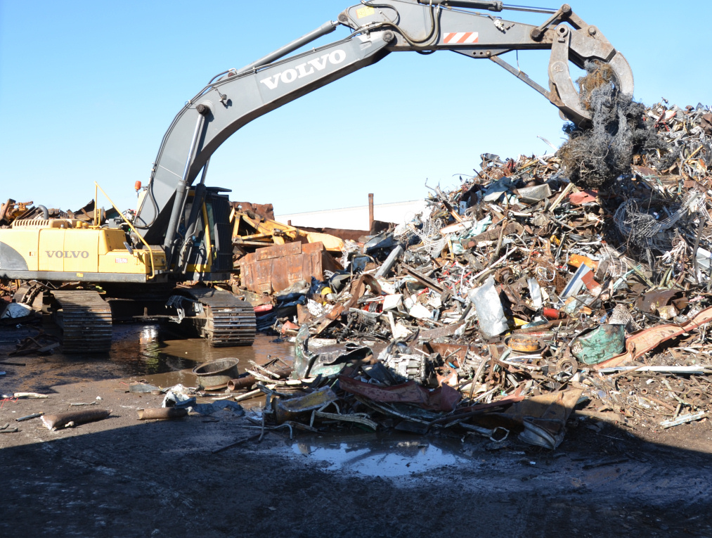 Photo of mechanical claw placing scrap metal onto huge pile, linking to photo album.