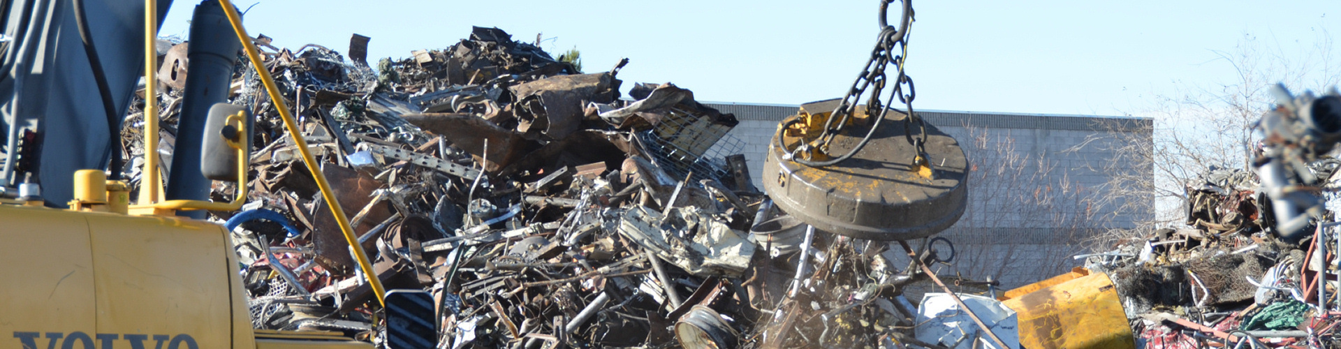 Photo of industrial electromagnet in action picking up scrap metal.