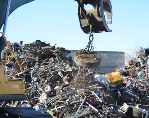 Photo of industrial electromagnet in action picking up scrap metal